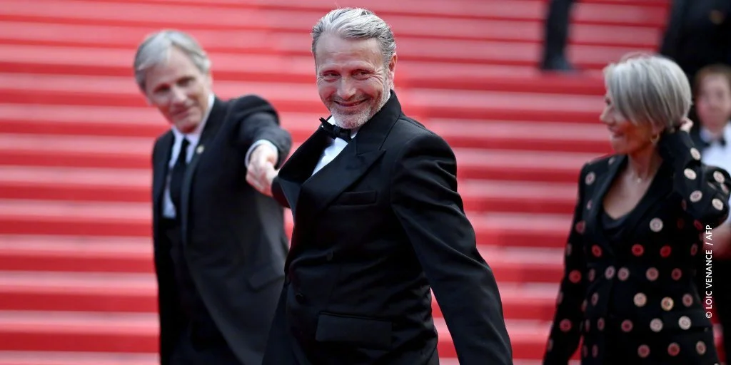 Mads Mikkelsen and Viggo Mortensen hold hands on the red carpet for the 75th anniversary of the Cannes Film Festival